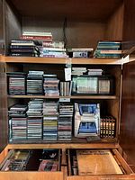 Overall view of cabinet showing Panasonic stereo, CDs, cassette holder, VHS tapes, lower drawers partially visible