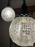 Close view of front globe showing faceted glass pattern and metal cap