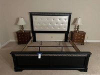 Full view of bed frame assembled with headboard, footboard, two nightstands and lamps