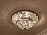 Oblique view of mounted chandelier showing crystal tiers and finial