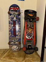 Front view of both skateboards showing graphics, trucks, wheels