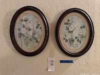 Both framed prints hanging side by side with measurement indicator