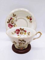 Overall view of teacup and saucer showing floral pattern and gold trim