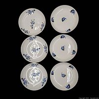All six plates, three fish motif on right, three dragon motif on left