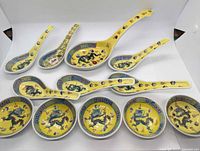 Full set of yellow Famille Rose spoons, ladle and sauce dishes laid out