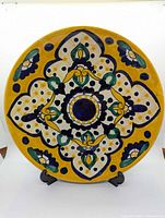 Front view of hand-painted Mexican folk art terra cotta wall plate showing full design