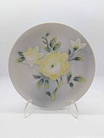 Full front view of ceramic plate with raised yellow peony design