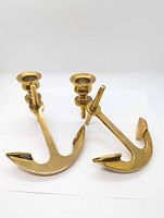 Oblique view of both brass anchor candlesticks showing shape and finish
