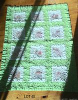 Full view of quilt showing nine embroidered cat blocks, green sashing and ruffled border