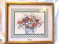 Front view of framed cross stitch floral bouquet with green lattice border