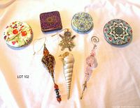 Overview of four tins and four ornaments on cloth background