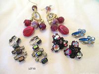 All three pairs of earrings arranged: red AB japanned, iridescent rectangular, blue rhinestone
