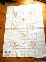 Full view of quilt showing size, grid layout, embroidered animals