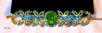 Full view of gold-tone bracelet with blue clusters and central green stone