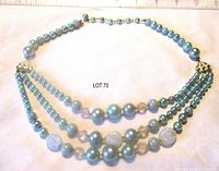 Full view of triple strand pale blue beaded necklace