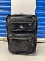 Front view showing brand badge, two exterior zip pockets