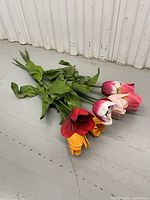 Bundle of six artificial tulip stems on floor