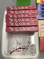 Stack of seven pink floral-covered volumes and additional grey cover