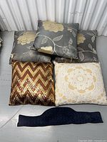 Group shot of all cushions including grey floral, sequin, cream lace and blue lumbar piece