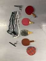 All items laid out: four paddles, net, two clamps, plaid cover