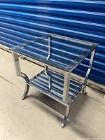 Perspective view showing glass top, chrome frame, mirrored lower shelf