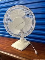 Front view of white Holmes oscillating desk fan on square base