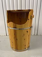 Front of vertical solid wood foot spa barrel showing metal bands and side handle