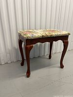 Full view of bench showing wood frame and floral upholstered seat