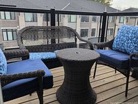 Loveseat, two chairs, and round table on balcony