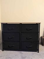 Front view showing six black fabric drawers in metal frame with wood-look top
