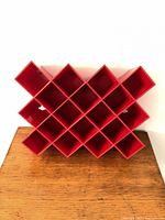 front view showing red plastic lattice rack with 24 square compartments