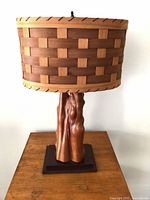 Full view of lamp showing woven veneer shade and cypress knees base on plinth