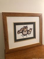 Framed Indigenous owl print on wood surface showing full frame