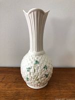 Front view of white Belleek vase showing basketweave body and flared rim