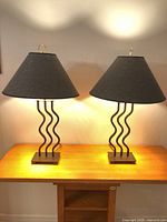 Both matching modernist table lamps lit on table