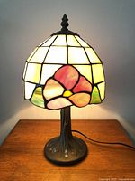 Overall view lit showing stained glass shade and metal base