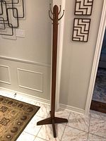 Full view of coat tree showing height, base, and finish wear
