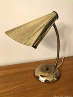 Full view of gold finish desk lamp showing gooseneck and base