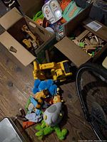 Overview of box with excavator, wooden tracks, plush toys