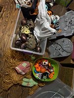 Overview of tote with tombstones, lights, masks, bowl, straw doll