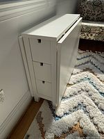Table folded into slim console showing three drawers on one side