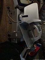 Left side view of Bizerba deli slicer showing blade, carriage and knobs