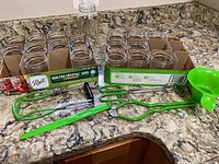 Two trays of Ball Quilted Crystal jars and green canning tools on countertop