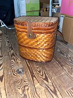 Closed wicker picnic basket on floor