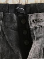 Front waistband showing wings + horns branded label and button fly