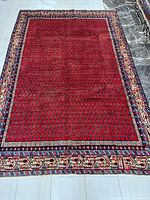 Full view of entire red field Persian Arak rug showing borders and size