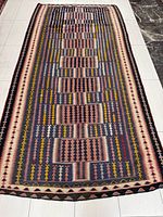 Full view of entire kilim rug laid flat showing pattern and borders