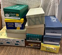 Stack of twelve shoe boxes showing brand names