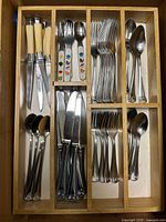 Drawer view showing full assortment of stainless flatware and knives