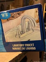 Front of retail box showing faucet image and branding